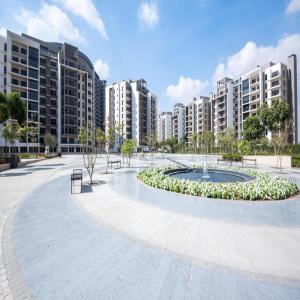 a park with a fountain in front of some buildings at Habitat Towers in Sheikh Zayed