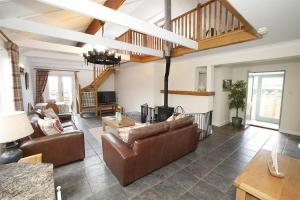 a living room with brown leather furniture and a staircase at 2 Bed in Gower oc-hh411 in Parkmill