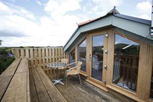 a cabin with a table and chairs on a deck at 2 Bed in Gower oc-hh411 in Parkmill