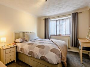 a bedroom with a bed and a desk and a window at 2 Bed in Mablethorpe oc-80703 in Sutton on Sea