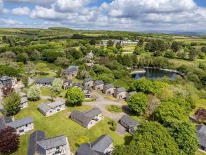 an aerial view of a village with houses and a lake at 2 Bed in Saltash oc-87709 in St. Mellion