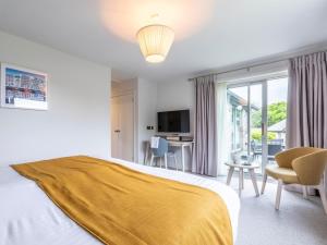 a bedroom with a bed and a desk and a television at 2 Bed in Saltash oc-87709 in St. Mellion