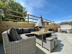 a patio with a couch and a table and chairs at 3 Bed in Pembroke oc-82584 in Lamphey