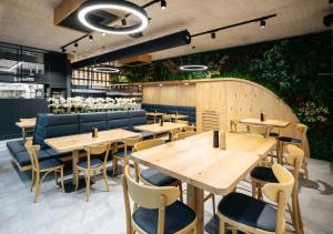 a restaurant with wooden tables and chairs and a hedge at Beachwell in Pelhřimov
