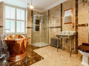 a bathroom with a copper tub and a shower at 9 Bed in Buxton oc-57932 in Buxton +32 photos