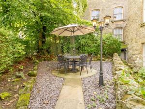 a table and chairs with an umbrella and a street light at 9 Bed in Buxton oc-57932 in Buxton