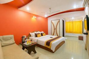 a hotel room with a bed and a couch at Hotel Ashoka Mountabu in Mount Ābu