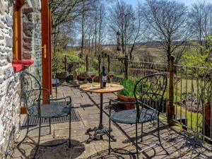 a table with two chairs and a bottle of wine at 1 Bed in Lampeter oc-43288 in Tregaron
