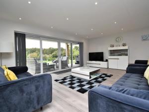 a living room with two blue couches and a television at 4 Bed in Oswestry oc-74110 in Kinnerley