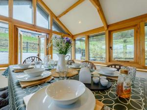 a dining room with a table and chairs and windows at 4 Bed in Llandysul oc-89422 in Cwm-pengraig