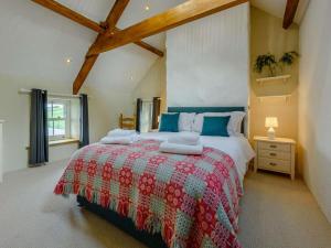 a bedroom with a large bed with a red blanket at 4 Bed in Llandysul oc-89422 in Cwm-pengraig