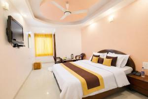 a bedroom with a large bed with a ceiling fan at Hotel Ashoka Mountabu in Mount Ābu