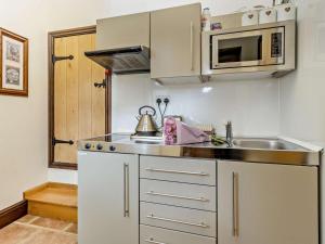 a small kitchen with a sink and a microwave at 2 Bed in Corwen oc-77351 in Corwen +19 photos