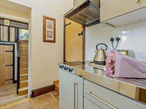 a kitchen with a stove and a kettle on a counter at 2 Bed in Corwen oc-77351 in Corwen
