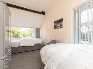 a bedroom with two beds and a window at 4 Bed in Bala oc-75288 in Llandderfel