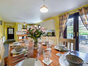 a dining room with a wooden table with flowers on it at 5 Bed in Llanybydder oc-75907 in Llanwenog