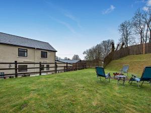 a yard with chairs and a table and a house at 5 Bed in Llanybydder oc-75907 in Llanwenog