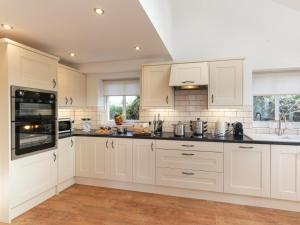 a kitchen with white cabinets and black counter tops at 4 Bed in Llandysul oc-66640 in Llandysul +20 photos