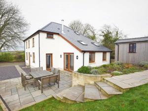 a white house with a table and benches in the yard at 4 Bed in Llandysul oc-66640 in Llandysul