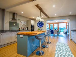 a kitchen with a blue island with bar stools at 5 Bed in Whitchurch oc-77696 in Whitchurch