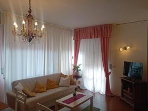 a living room with a couch and a chandelier at Garda City Home Family Apartments in Garda