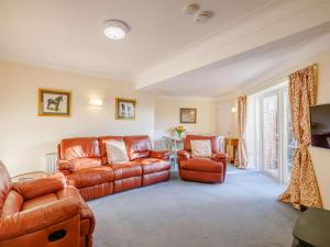a living room with a leather couch and two chairs at 2 Bed in Wrexham oc-43916 in Overton