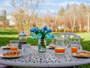 a table with plates of food and a vase of blue flowers at 2 Bed in Wrexham oc-43916 in Overton +6 photos