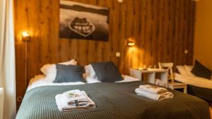a bedroom with a bed with towels on it at Kartanohotelli Artturi in Söderkulla