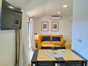 a living room with a yellow couch and a table at Alojamientos arans in La Cañiza