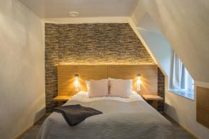 a bedroom with a large bed with a brick wall at Kartanohotelli Artturi in Söderkulla