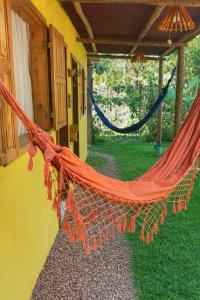 a hammock hanging outside of a house at Pousada Raízes do Cipó in Serra do Cipo