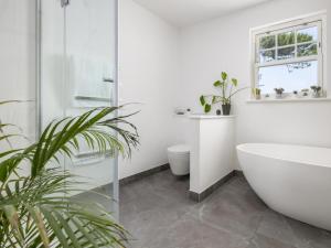 a bathroom with a tub and a toilet and a sink at 5 Bed in Bude oc-85698 in Poughill +54 photos