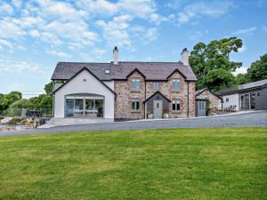 a large brick house with a green lawn at 5 Bed in Denbigh oc-86009 in Llandyrnog