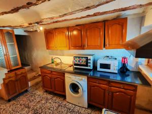 a kitchen with a washing machine and a microwave at Casa Serrana in Quesada