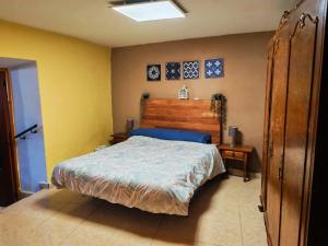 a bedroom with a bed with a wooden head board at Casa Serrana in Quesada