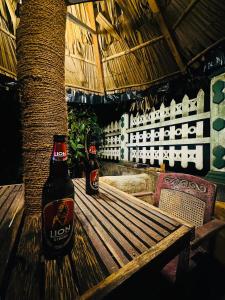 two bottles of beer sitting on a wooden bench at Tuskers edge Retreat in Udawalawe