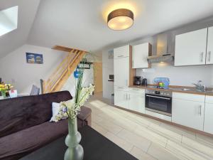 a living room with a couch and a kitchen at Ferienwohnung Südwind Norddeich in Norden