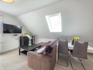 a living room with a couch and a table at Ferienwohnung Südwind Norddeich in Norden