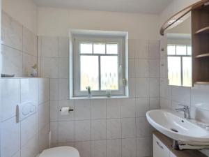 a bathroom with a sink and a toilet and a window at Ferienwohnung Südwind Norddeich in Norden +20 photos