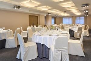 a banquet room with white tables and white chairs at Hesperia Bilbao in Bilbao