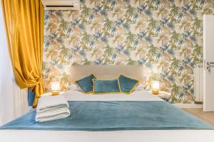 a bedroom with a bed with a blue blanket and two pillows at Casa flowers in Ciampino