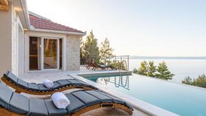 a swimming pool with a pool noodle next to a house at Villa Silvana by Villas Guide in Blato