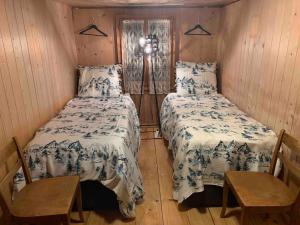 a bedroom with two beds and a lamp in it at Swiss Mountain Chalet in Saxeten