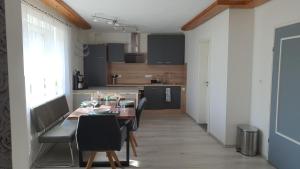 a kitchen with a wooden table and chairs in a room at Ferienwohnung Christel und Andreas in Sulzfeld