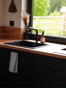 a black sink in a kitchen with a window at Owczarnia Tatry in Bukowina Tatrzańska +105 photos