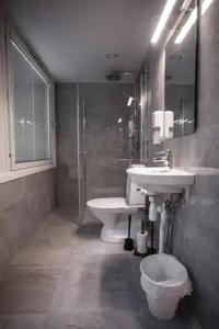 a bathroom with a sink and a toilet and a mirror at Hotel Aveny in Gävle +14 photos