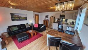 a living room with black furniture and a kitchen at Jungholz Erlebnis in Jungholz