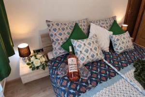 a bottle of wine sitting on a bed with pillows at Fehérvár Cappuccino apartman City center, AC, Easy Parking in Székesfehérvár