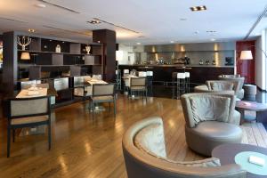 a restaurant with chairs and tables and a bar at Hesperia Bilbao in Bilbao