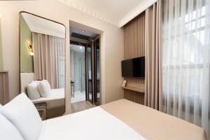 a hotel room with a bed and a mirror at Atik Hotel Nişantaşı in Istanbul